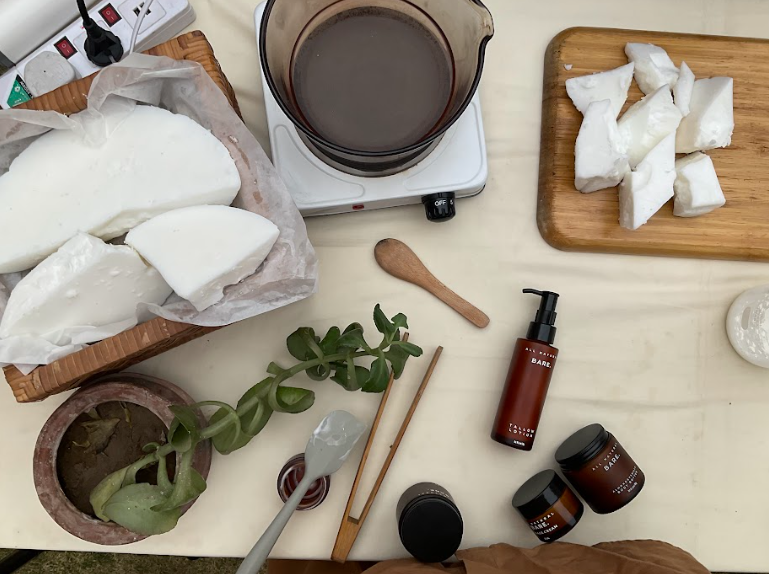 Tabletop scene with tallow rendering ingredients — pot, containers, and botanicals