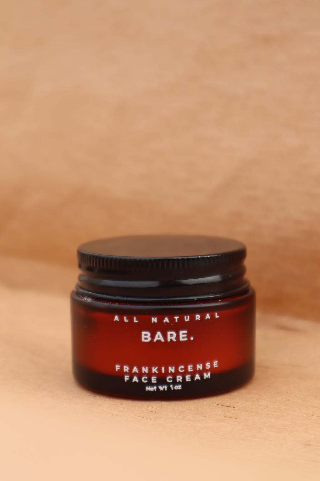 Jar of Bare All Natural Frankincense Face Creme on a wooden surface