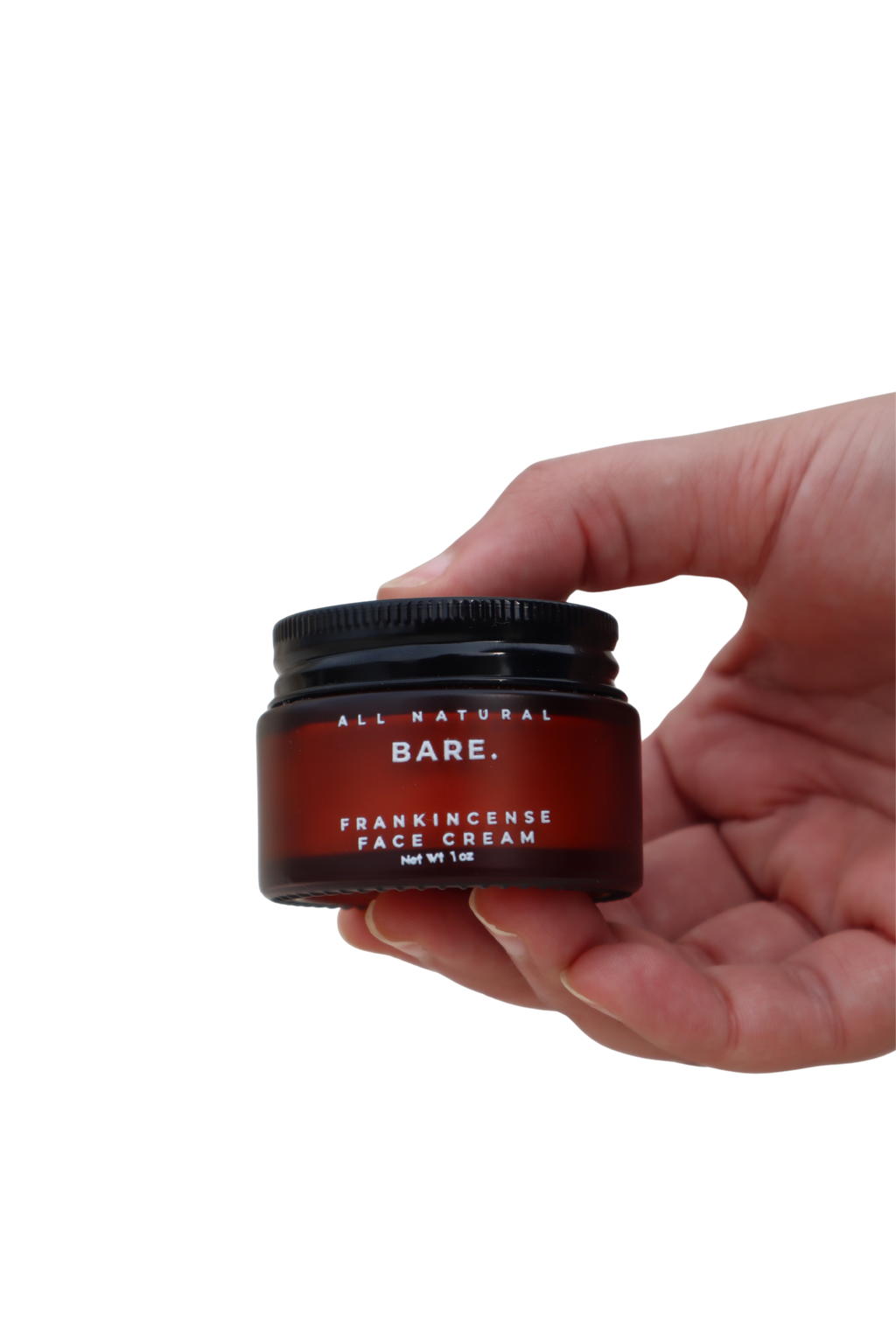 Hand holding a frosted amber glass jar of Bare Naturals Frankincense Face Cream on a clean white background, rich tallow face moisturizer for dry, normal and sensitive skin, non-comedogenic anti-aging skincare.